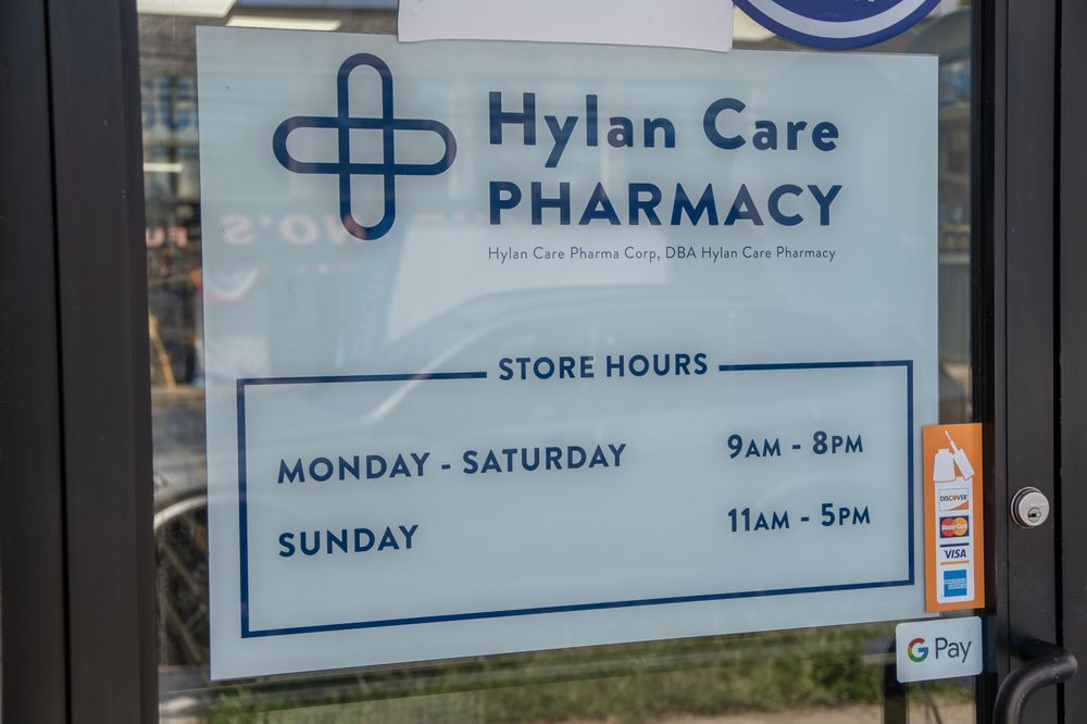 Store hours displayed at the entrance of Hylan Care Pharmacy